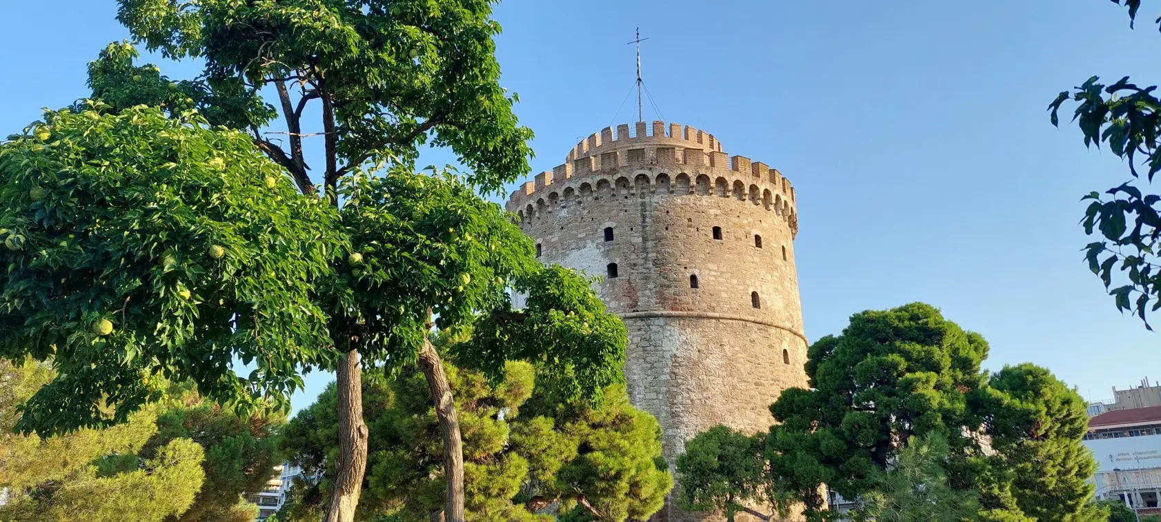 Bijela kula među zelenim drvećem ljeti